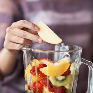 placing fruit into a blender